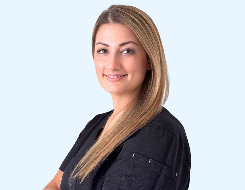 Sourire confiant d'une dentiste femme en blouse noire dans un cabinet dentaire moderne.